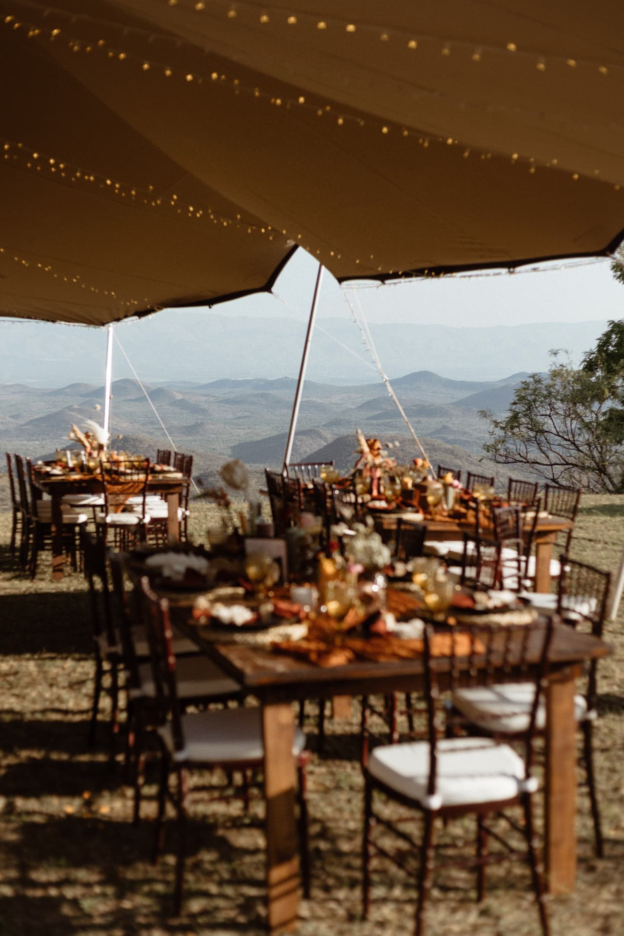 Wedding tables under a stretch tent overlooking the valley