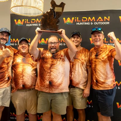 Winning team lifting the trophy in orange club shirts