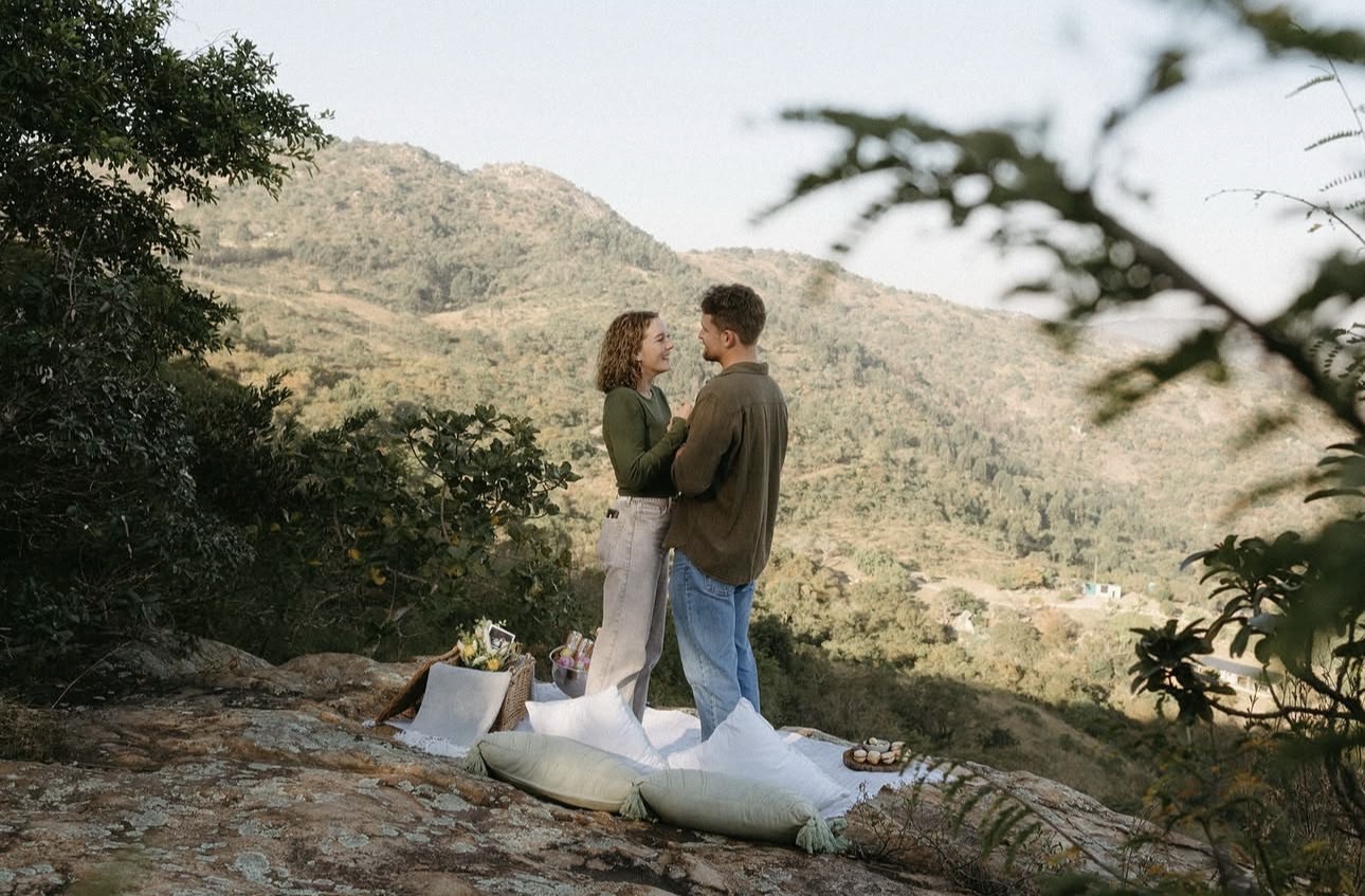 Couple at a picnic setup on a rocky outcrop