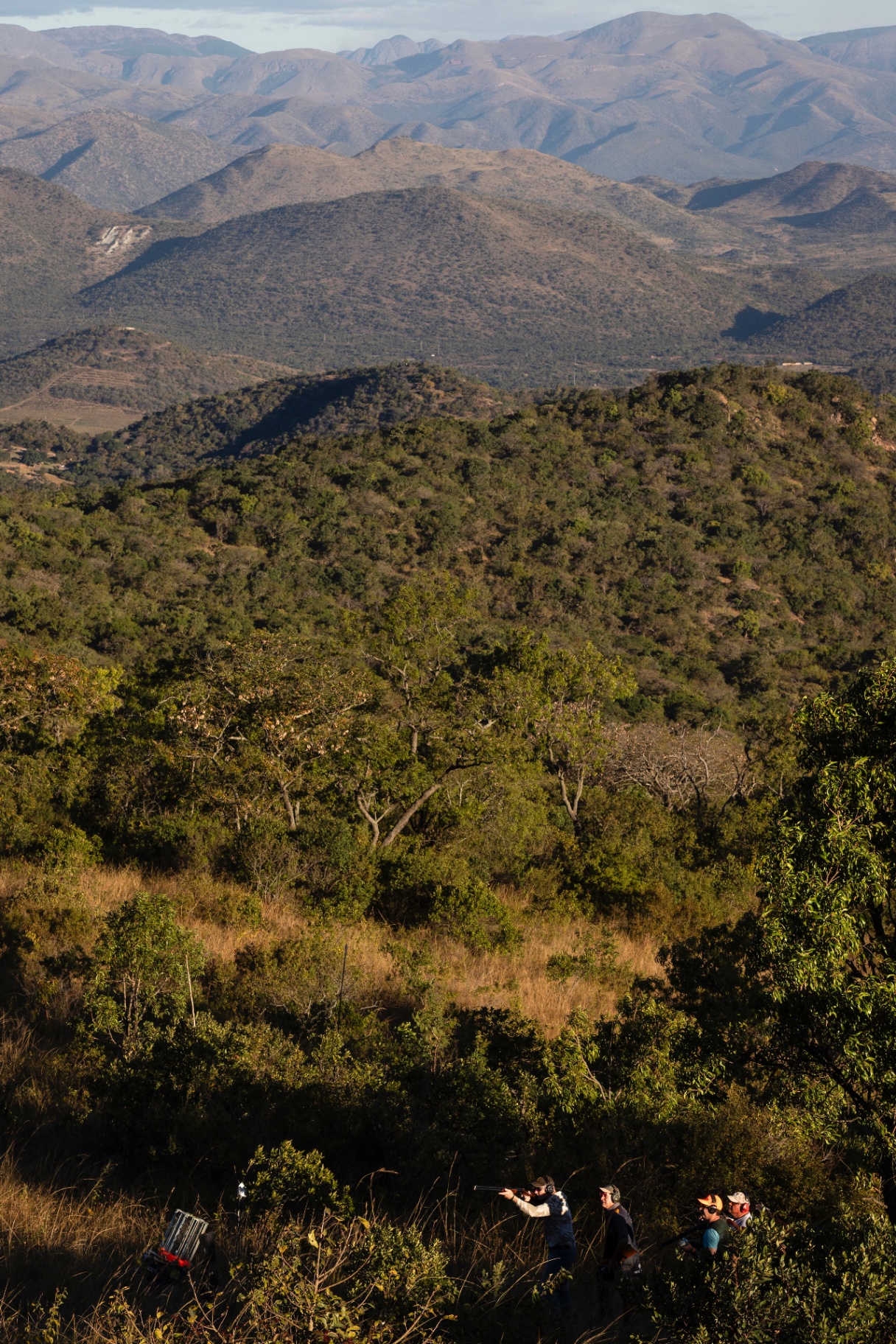 Shooter on the stand at Gold Valley Gun Club with the Lowveld mountains behind