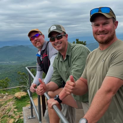 Three members giving a thumbs-up on a ridge above Gold Valley