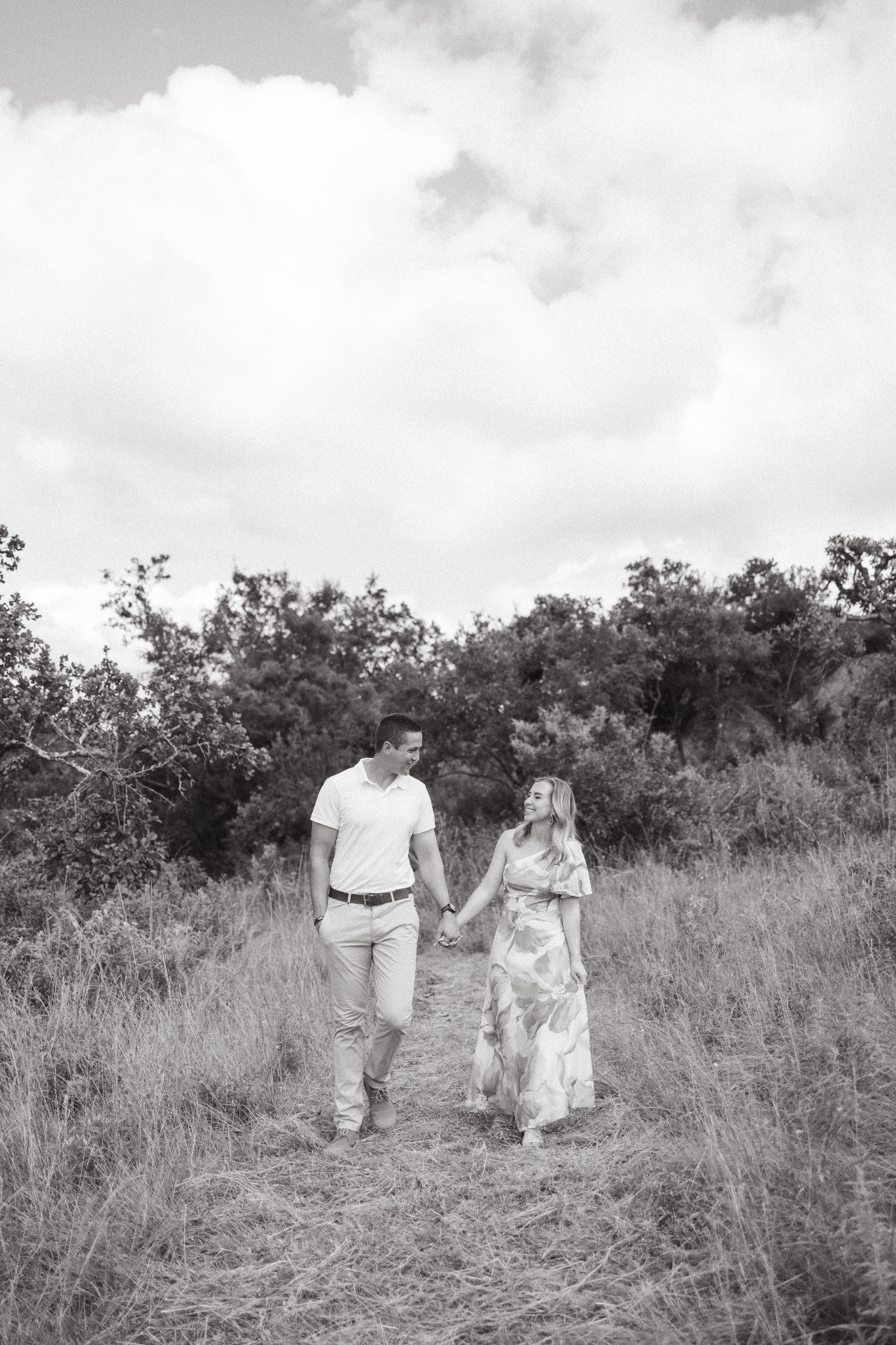 Engagement portrait, black and white, walking through long grass
