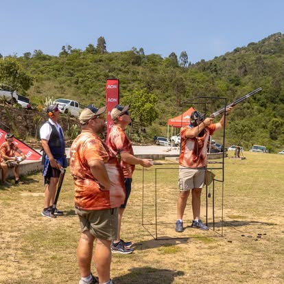Shooter mounting the gun with a spotter at Gold Valley Gun Club
