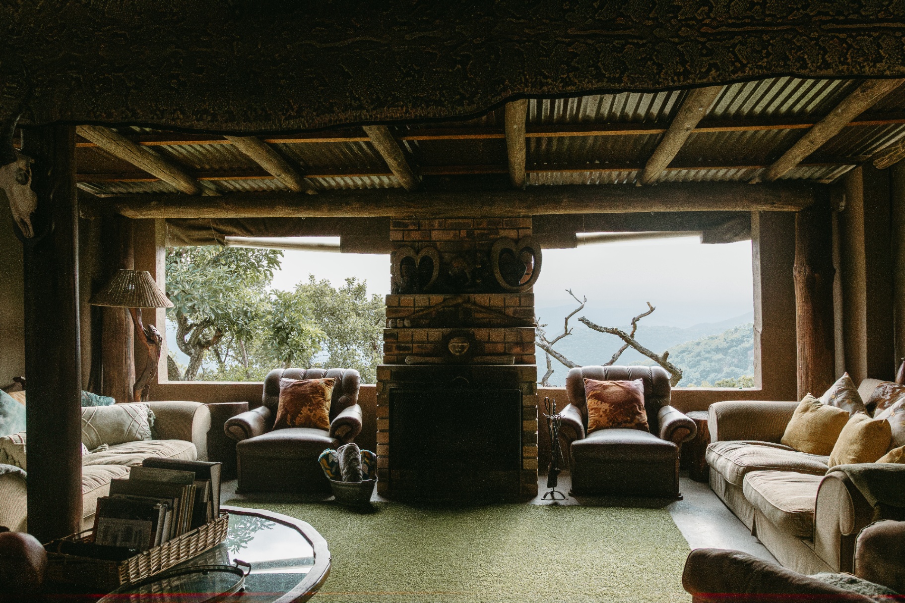 Stone-fireplace lounge with leather armchairs at Gold Valley Lodge