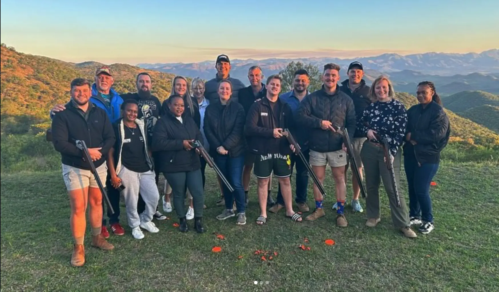 Corporate group on the range at sunset