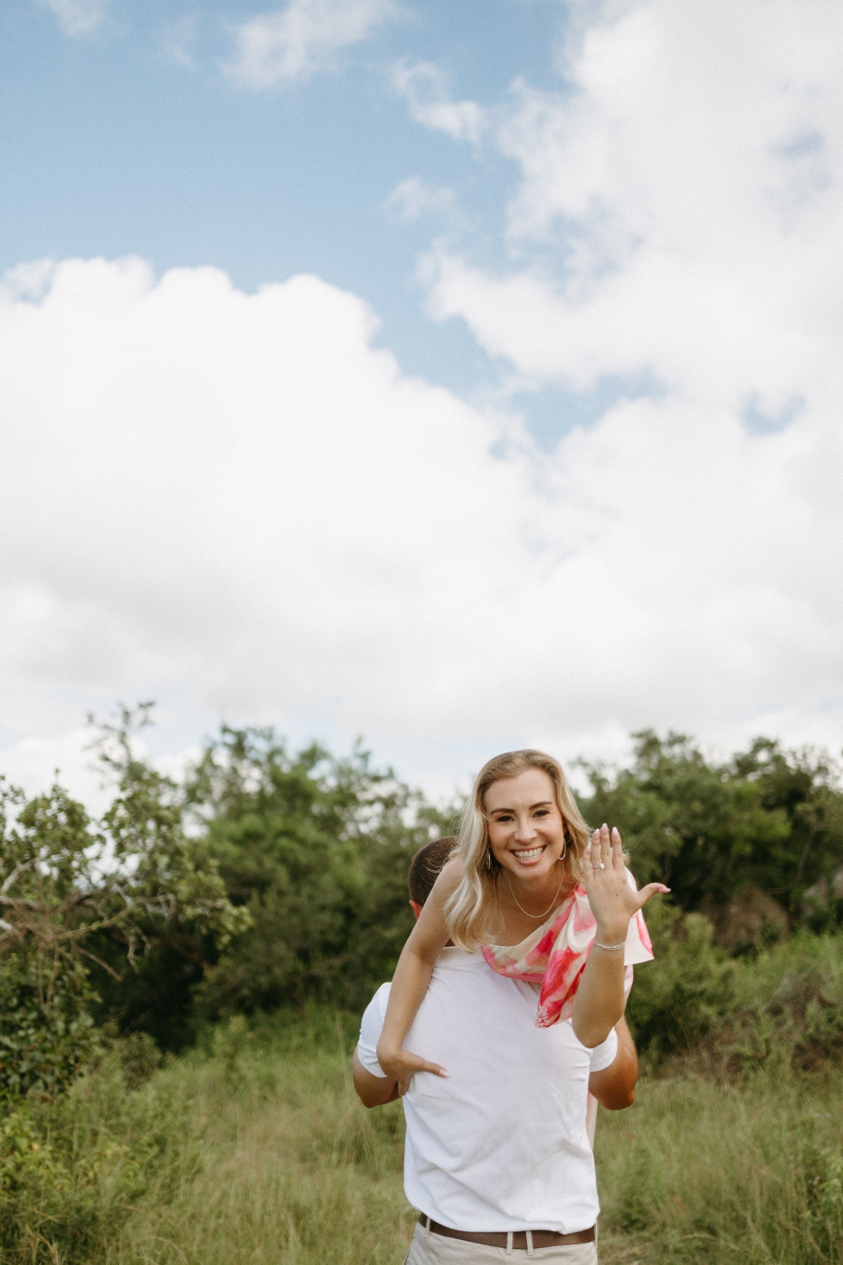 Woman on partner's back showing engagement ring