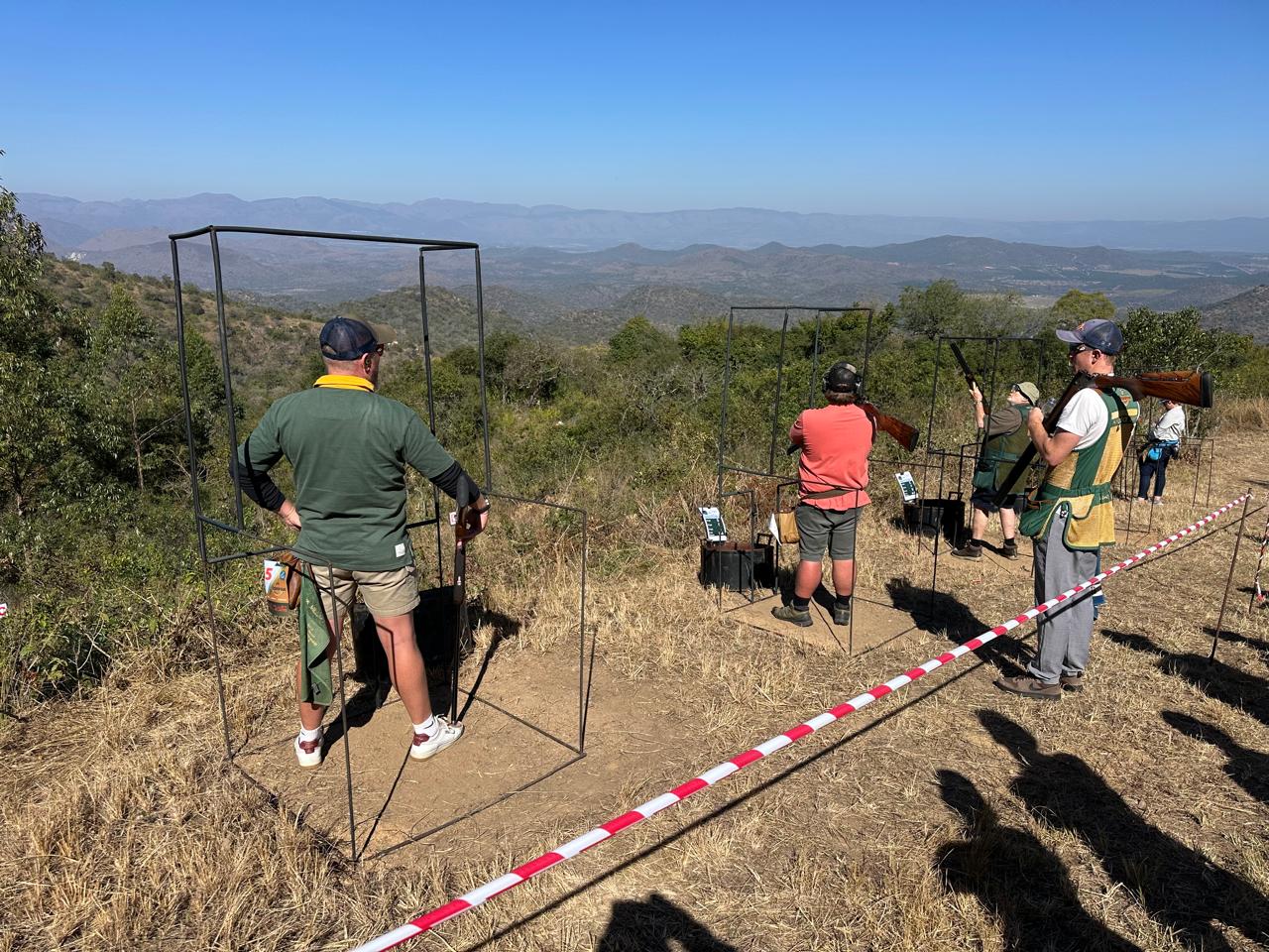 Shooters competing at the Gold Valley Gun Club range with the Lowveld mountains behind them