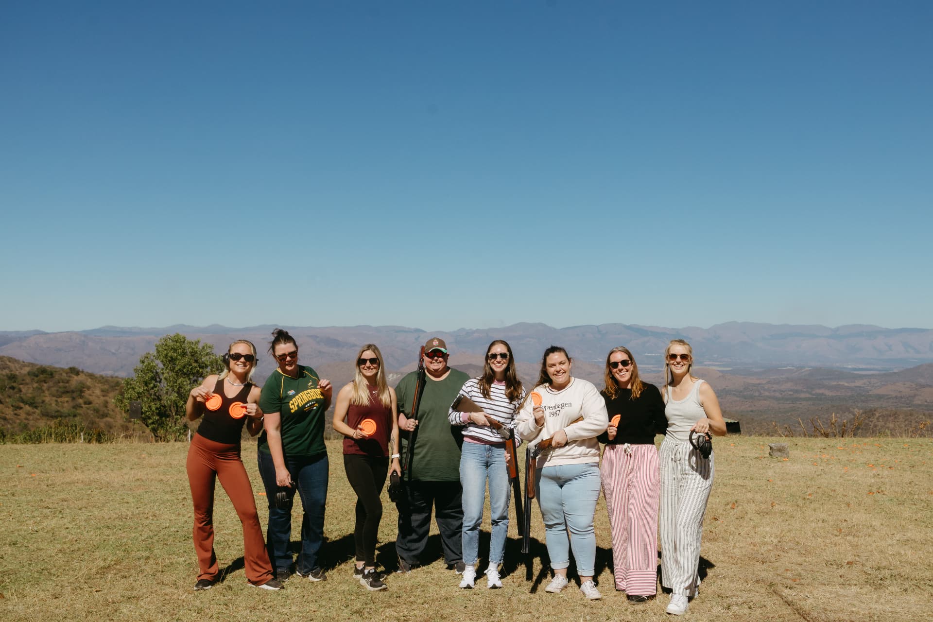 Group portrait on the range holding clay targets