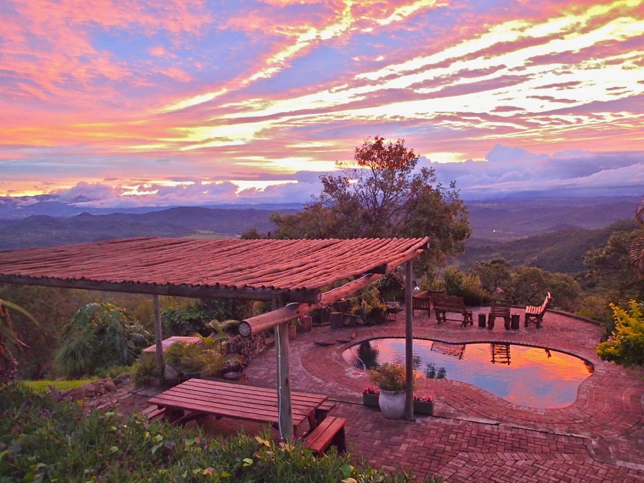 Pool and pergola at Gold Valley Lodge under a pink Lowveld sunset